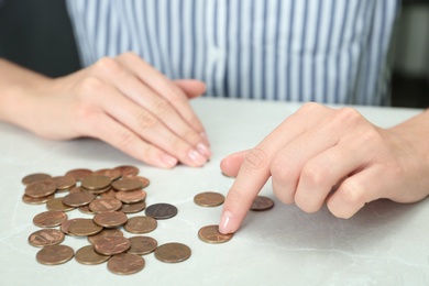 Photo of Woman counting coins at light table, closeup