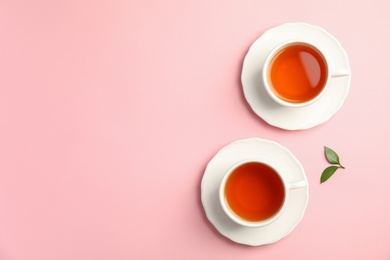 Flat lay composition with delicious tea and green leaves on color background