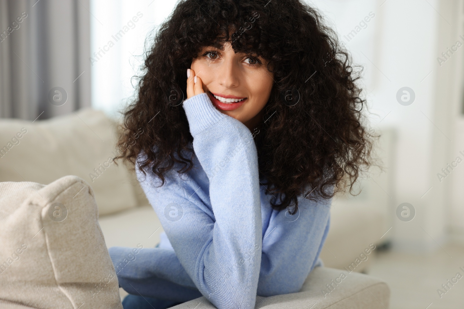 Photo of Happy young woman in stylish light blue sweater indoors