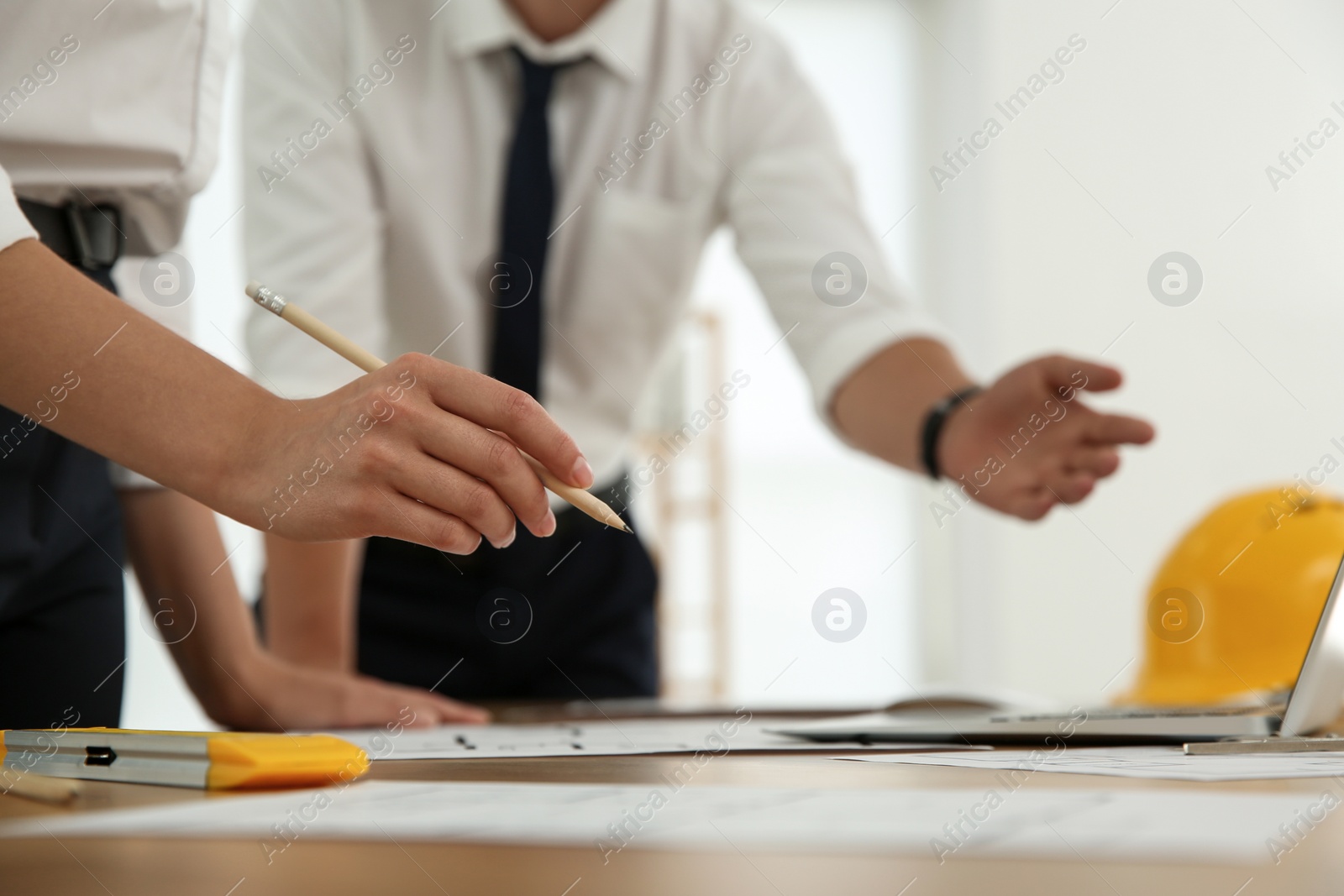 Photo of People working with construction drawings at table, closeup