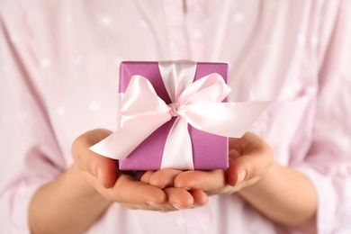 Photo of Woman holding gift box, closeup. Valentine's Day celebration