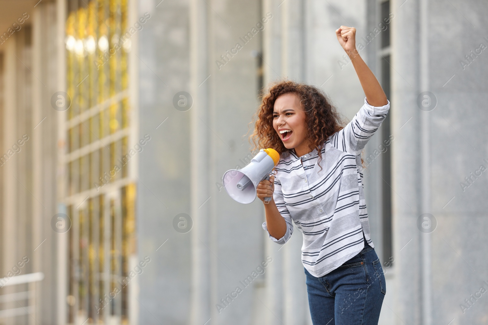 Image of Emotional African American young woman with megaphone outdoors. Protest leader