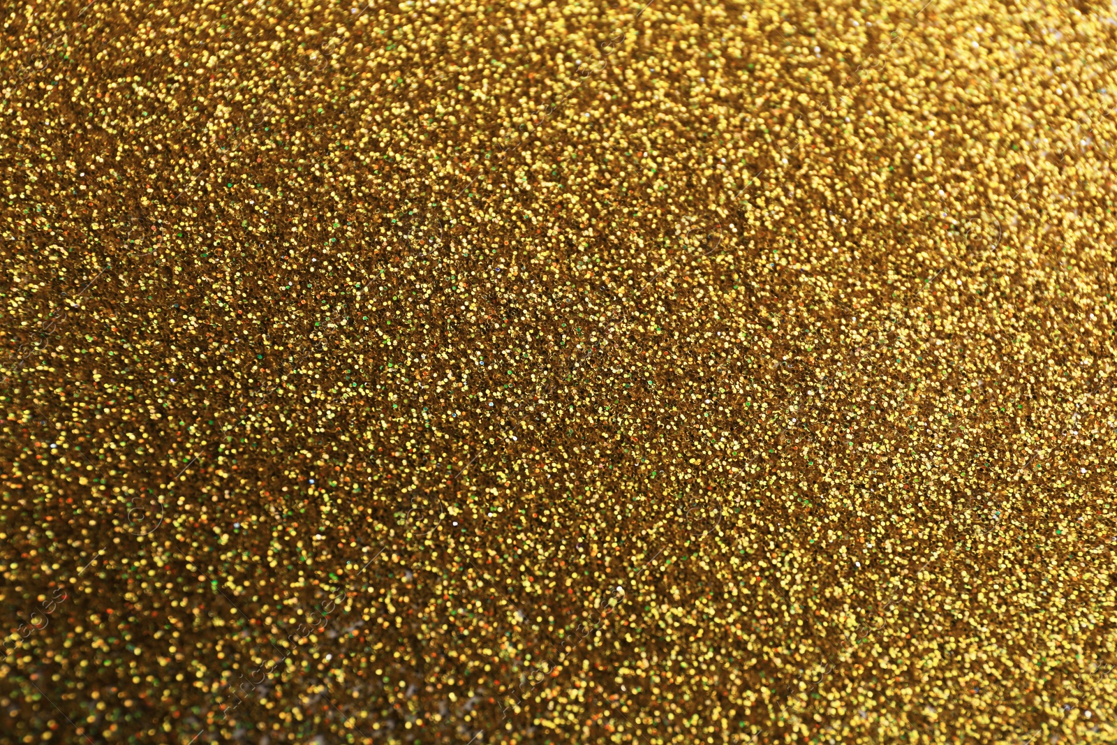 Photo of Closeup view of sparkling golden glitter background