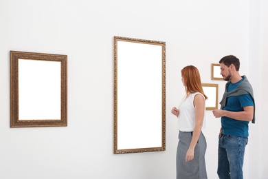 Photo of Couple viewing exposition in modern art gallery