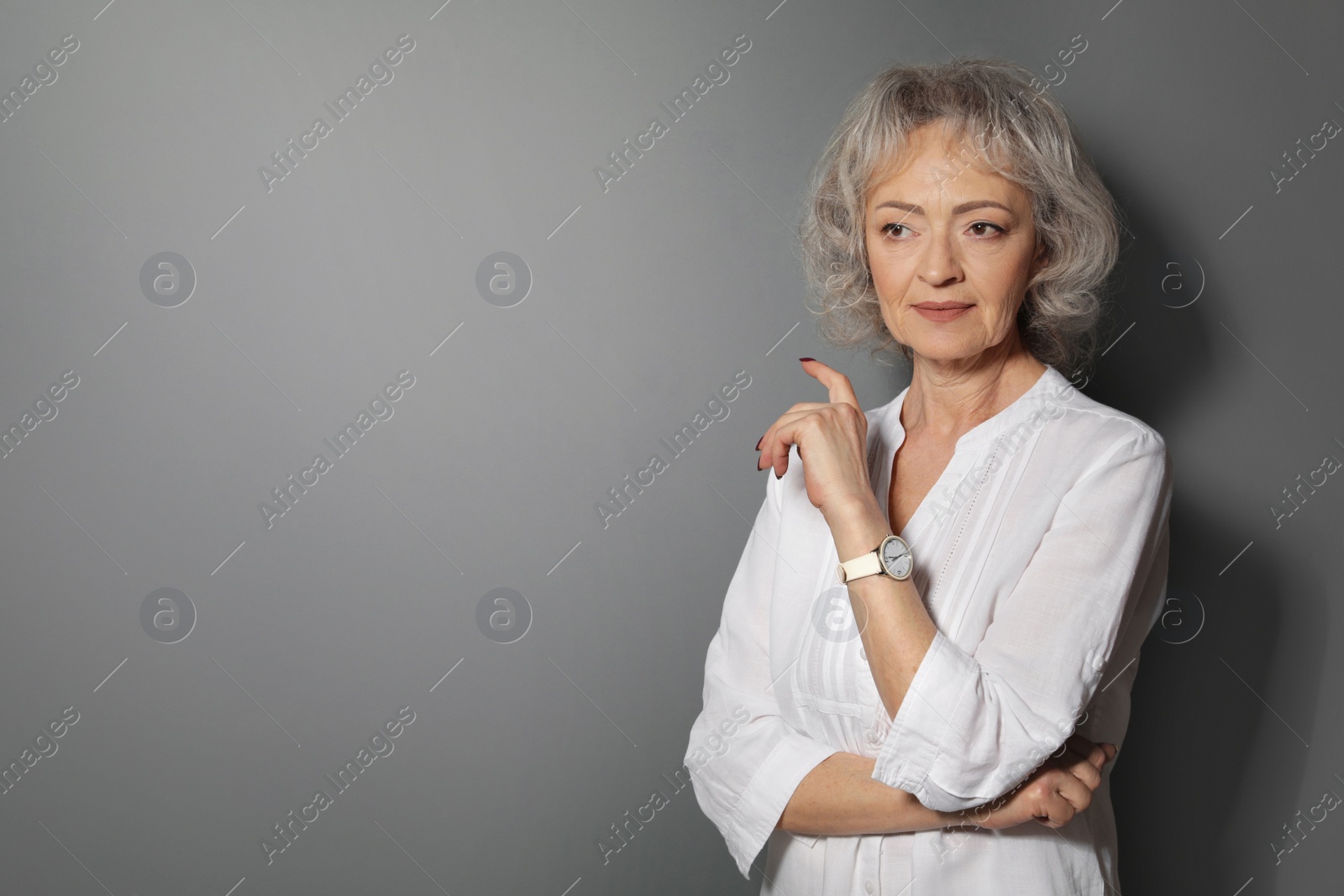 Photo of Portrait of mature woman on grey background. Space for text