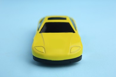 Photo of One yellow car on light blue background. Children`s toy