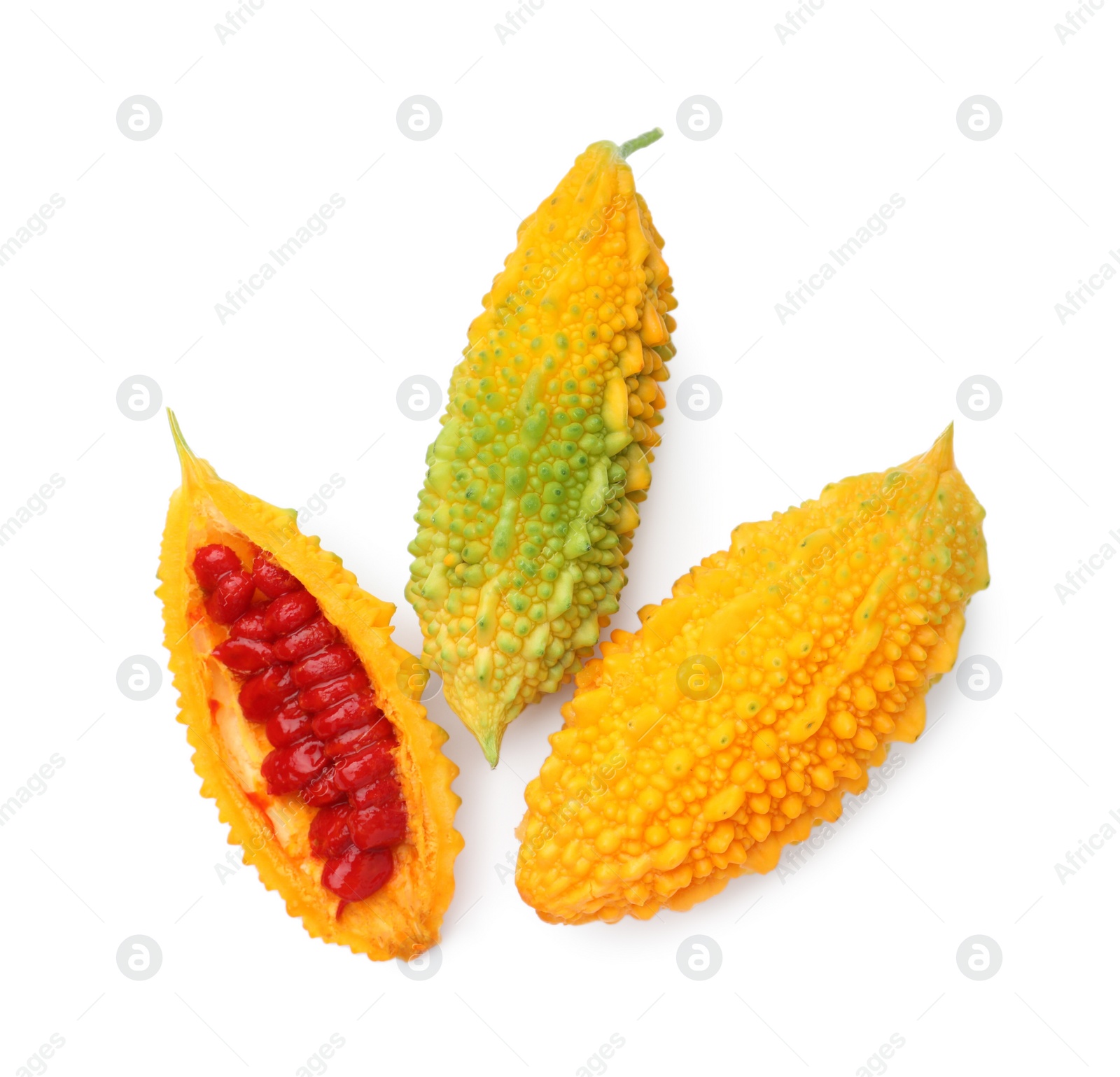 Photo of Whole and cut ripe bitter melons on white background, top view