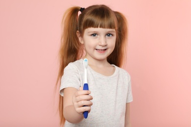 Photo of Little girl with toothbrush on color background. Teeth care