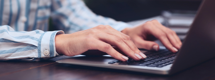 Image of Young woman working on computer at table indoors, closeup. Banner design