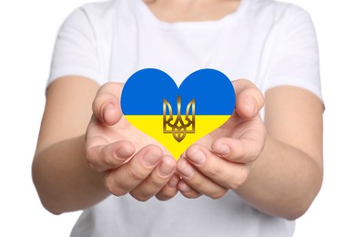 Stop war in Ukraine. Woman holding heart shaped symbol with colors of Ukrainian flag and Tryzub in hands on white background, closeup
