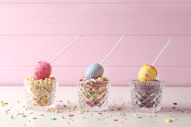 Photo of Egg shaped cake pops for Easter celebration on white wooden table