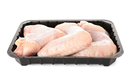 Photo of Plastic container with raw chicken wings on white background. Fresh meat
