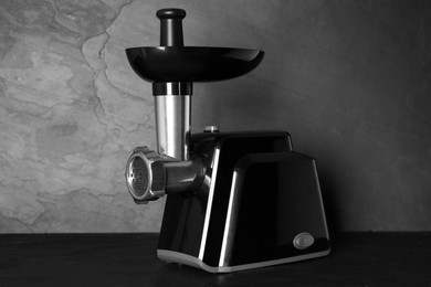 Photo of Modern electric meat grinder on black table