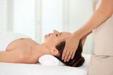 Photo of Beautiful young woman enjoying massage in spa salon