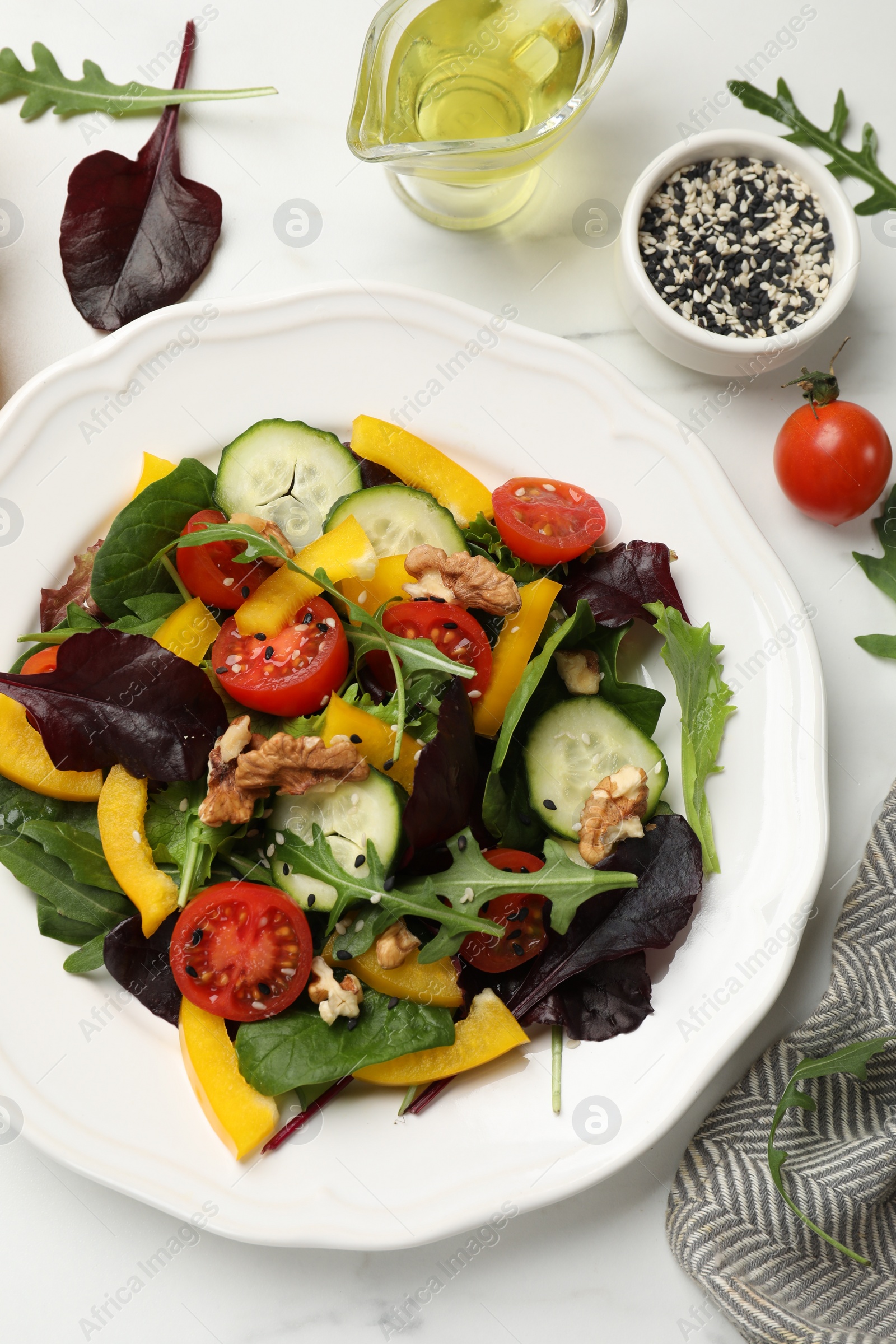 Photo of Tasty fresh vegetarian salad and ingredients on white marble table, flat lay