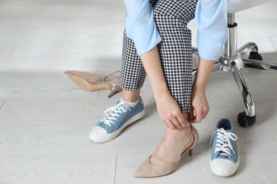 Photo of Woman changing shoes at workplace in office, closeup