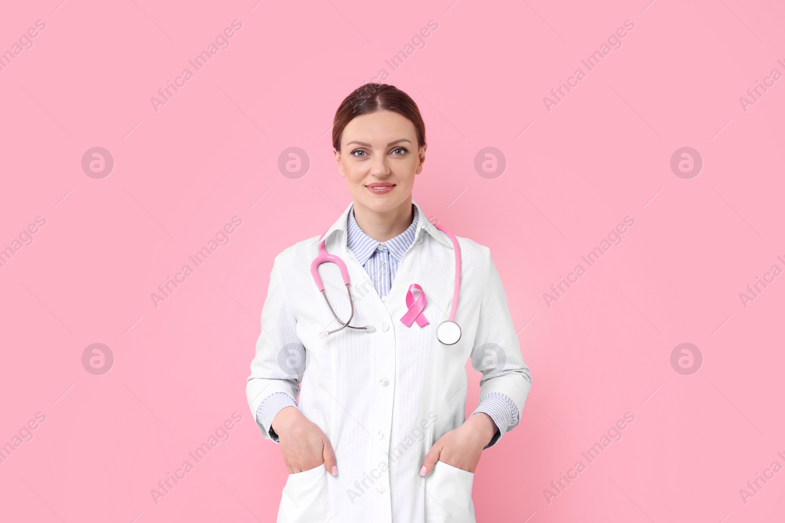 Photo of Mammologist with pink ribbon on color background. Breast cancer awareness