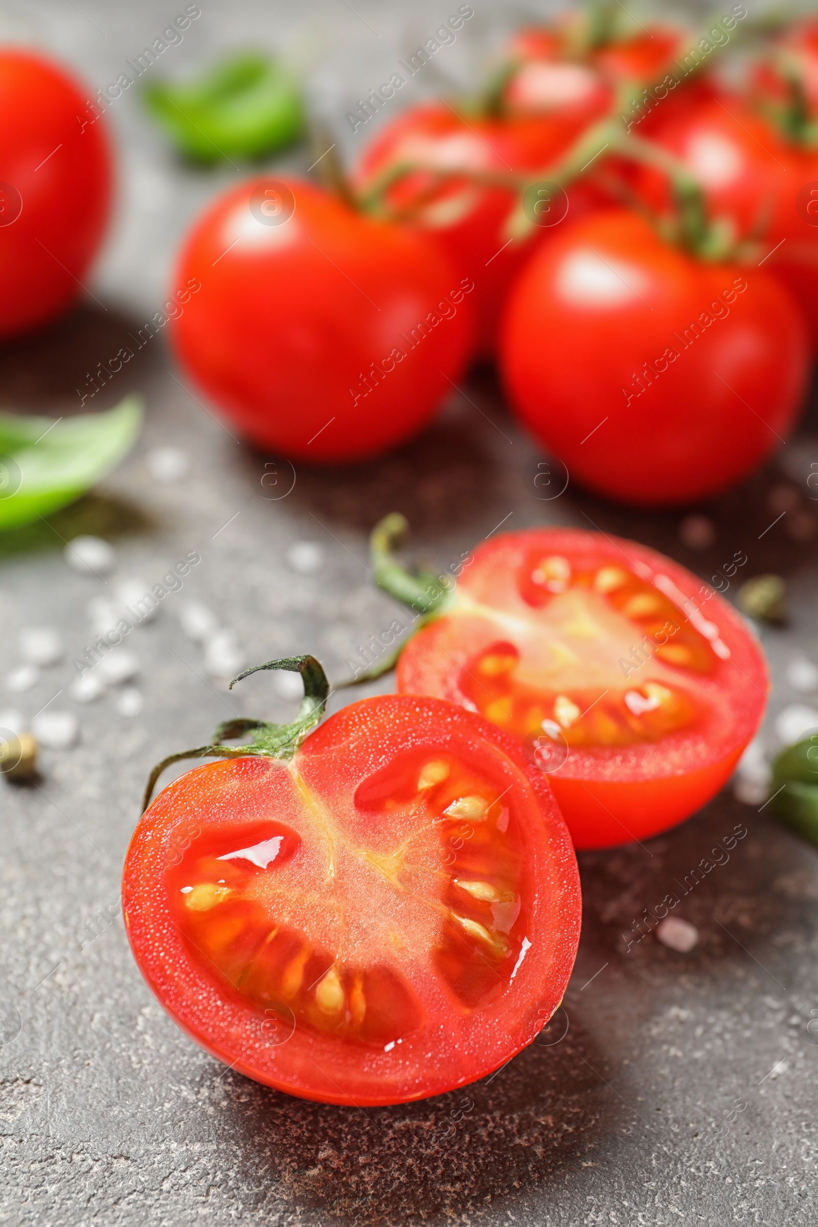 Photo of Cherry tomatoes with spice and basil on stone background