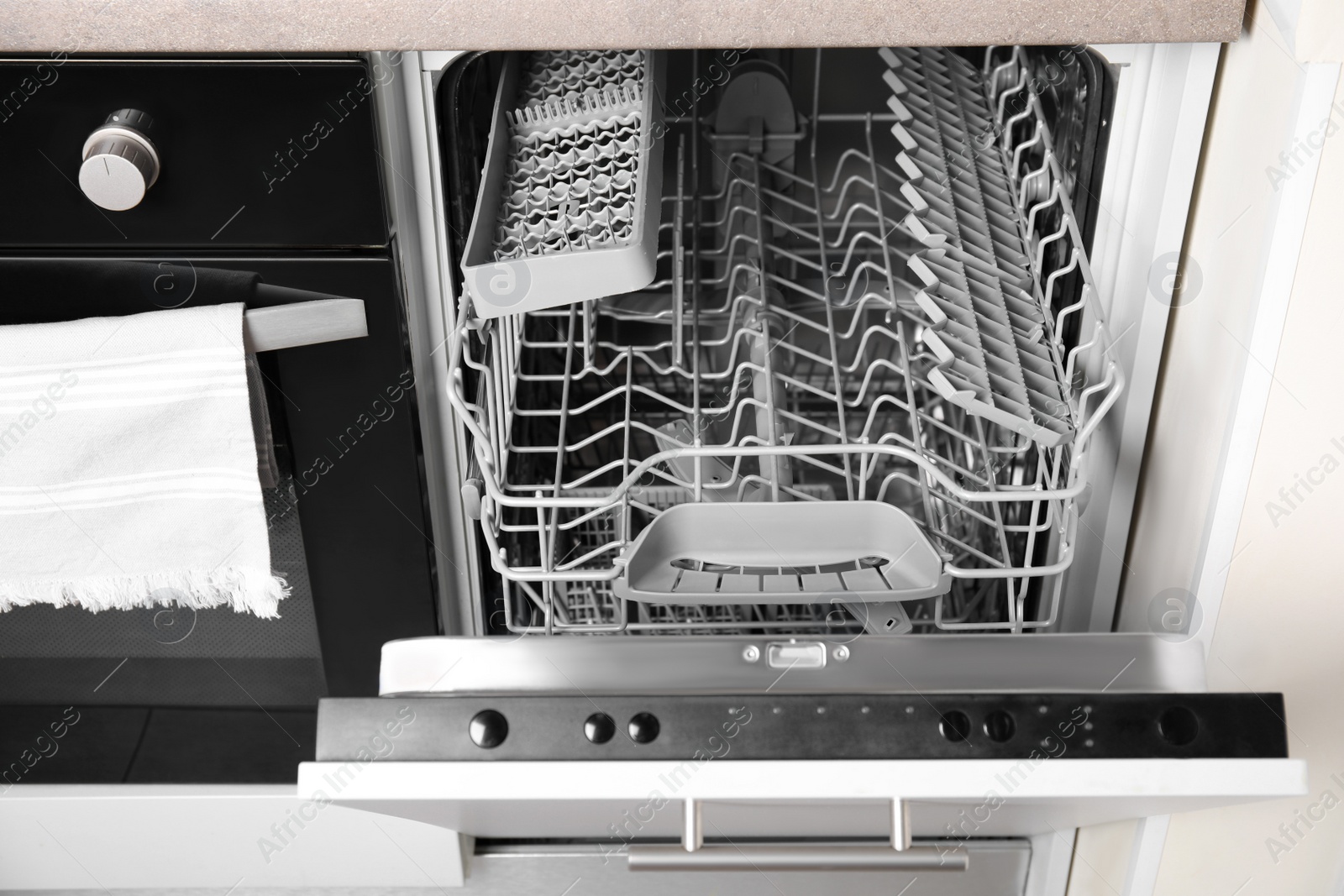 Photo of Open clean empty dishwasher in kitchen. Home appliance