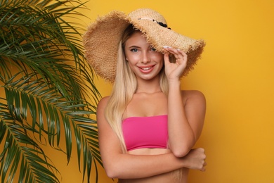 Pretty young woman wearing stylish bikini on orange background