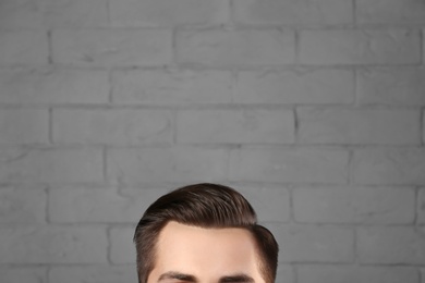 Man with beautiful hair on brick wall background, closeup