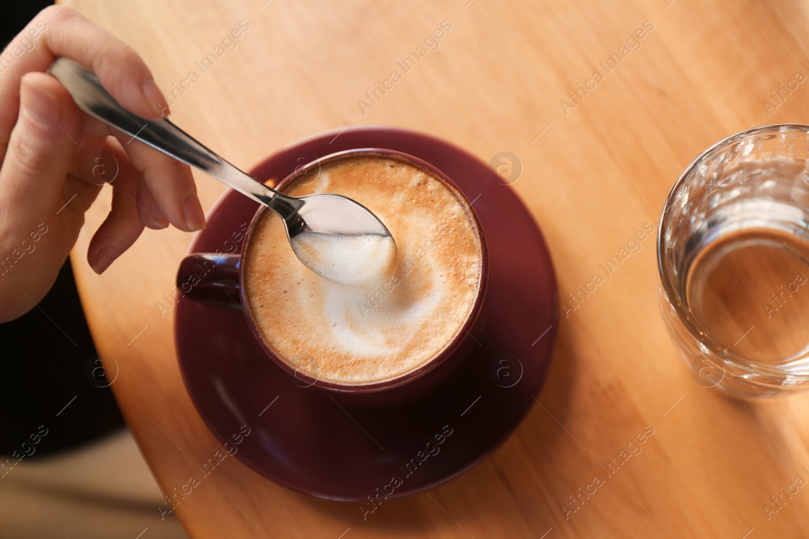 Photo of Woman with aromatic coffee at table in cafe, above view