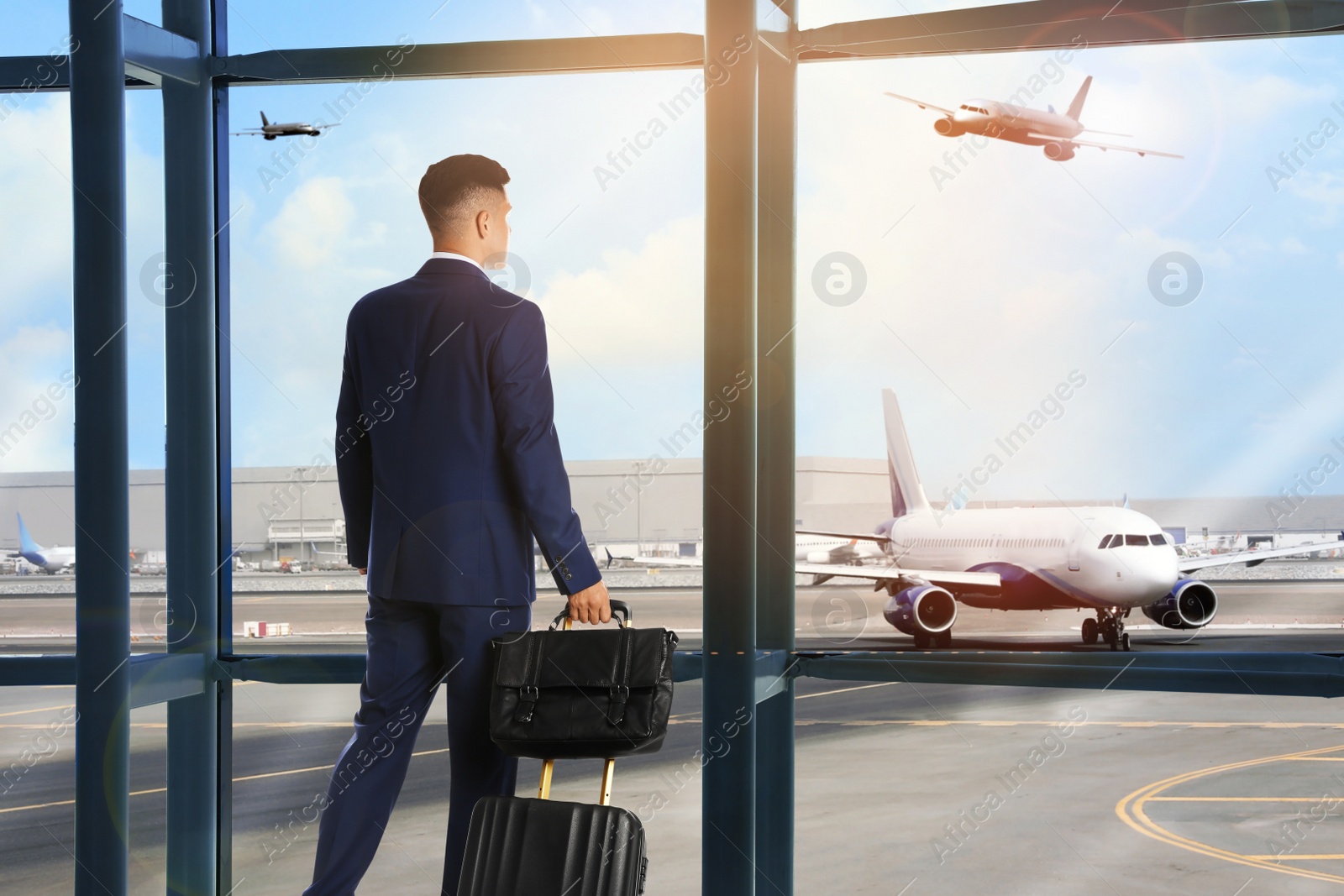 Image of Businessman with bag and travel suitcase at airport terminal. Summer vacation