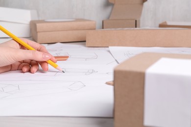 Photo of Woman creating packaging design at table, closeup