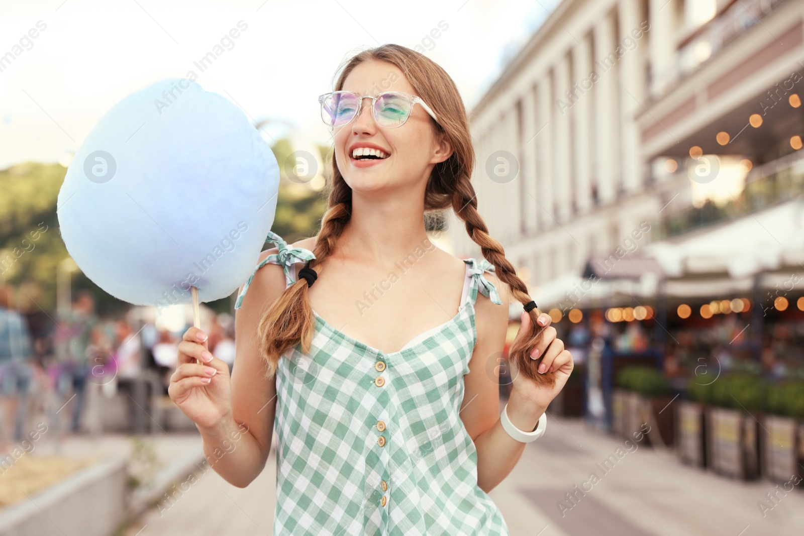 Photo of Young woman with cotton candy on city street