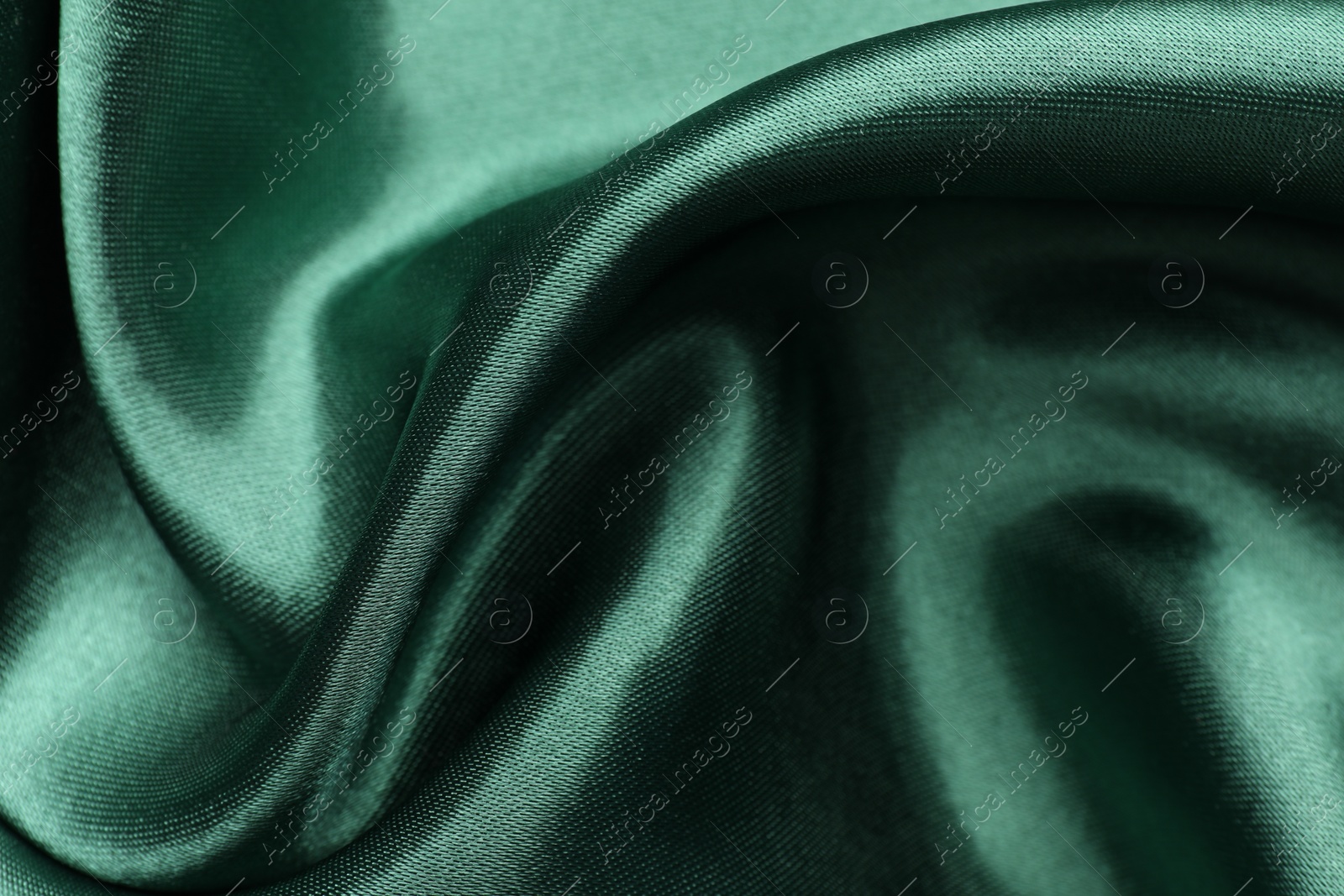 Photo of Crumpled green silk fabric as background, closeup