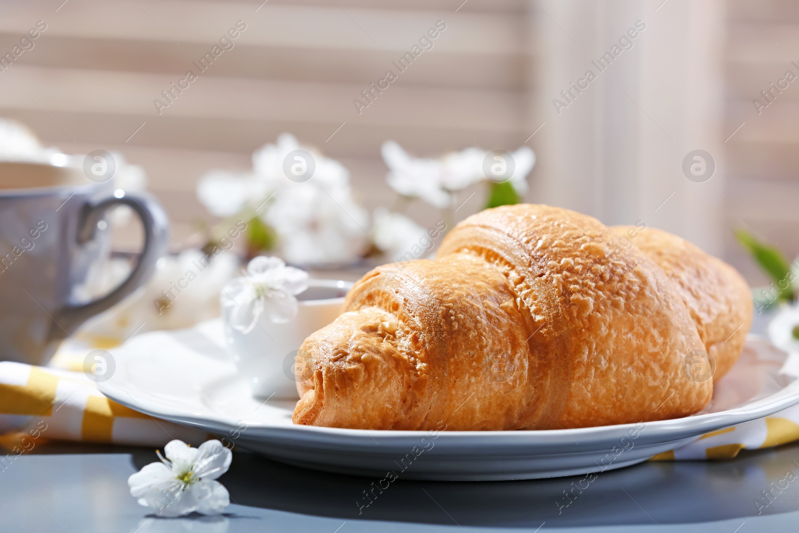 Photo of Plate with tasty croissant for breakfast on table