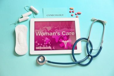 Photo of Flat lay composition with tablet, stethoscope and feminine hygiene items on color background. Gynecological care