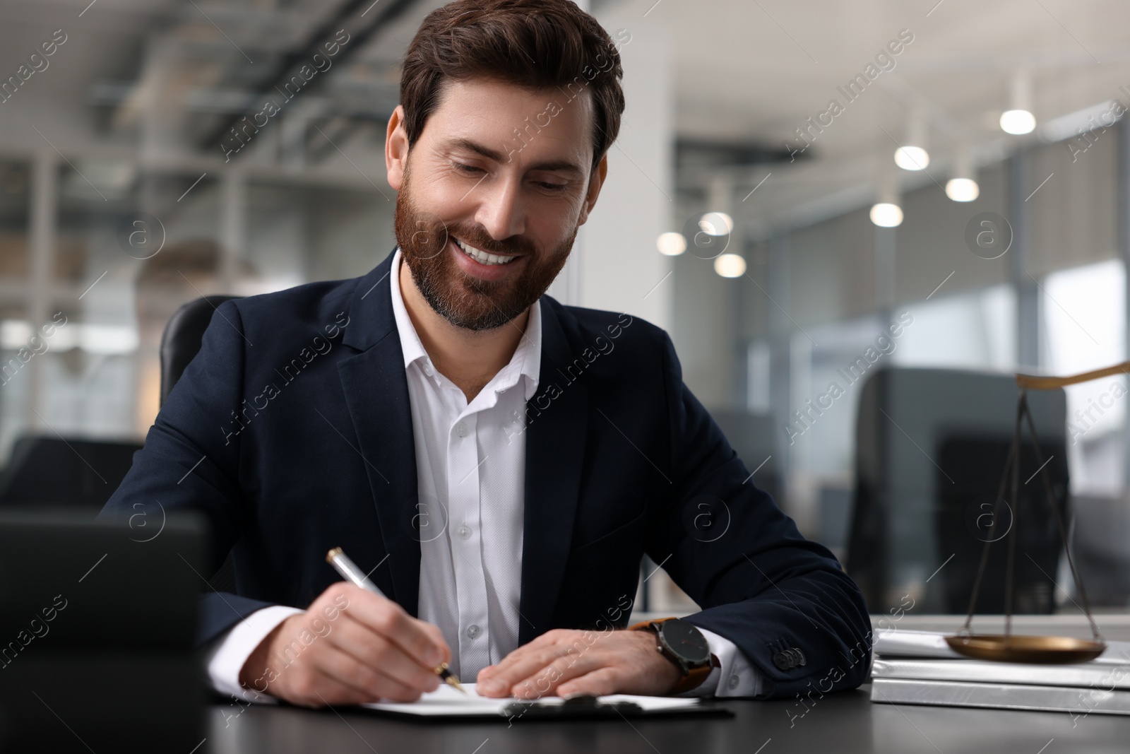 Photo of Portrait of smiling lawyer at table in office