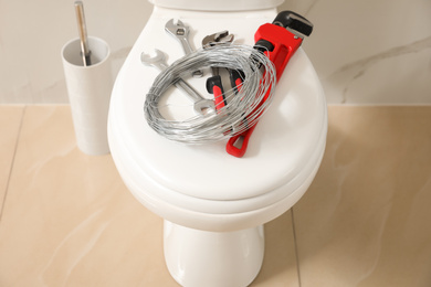 Plumber's tools on toilet bowl in bathroom