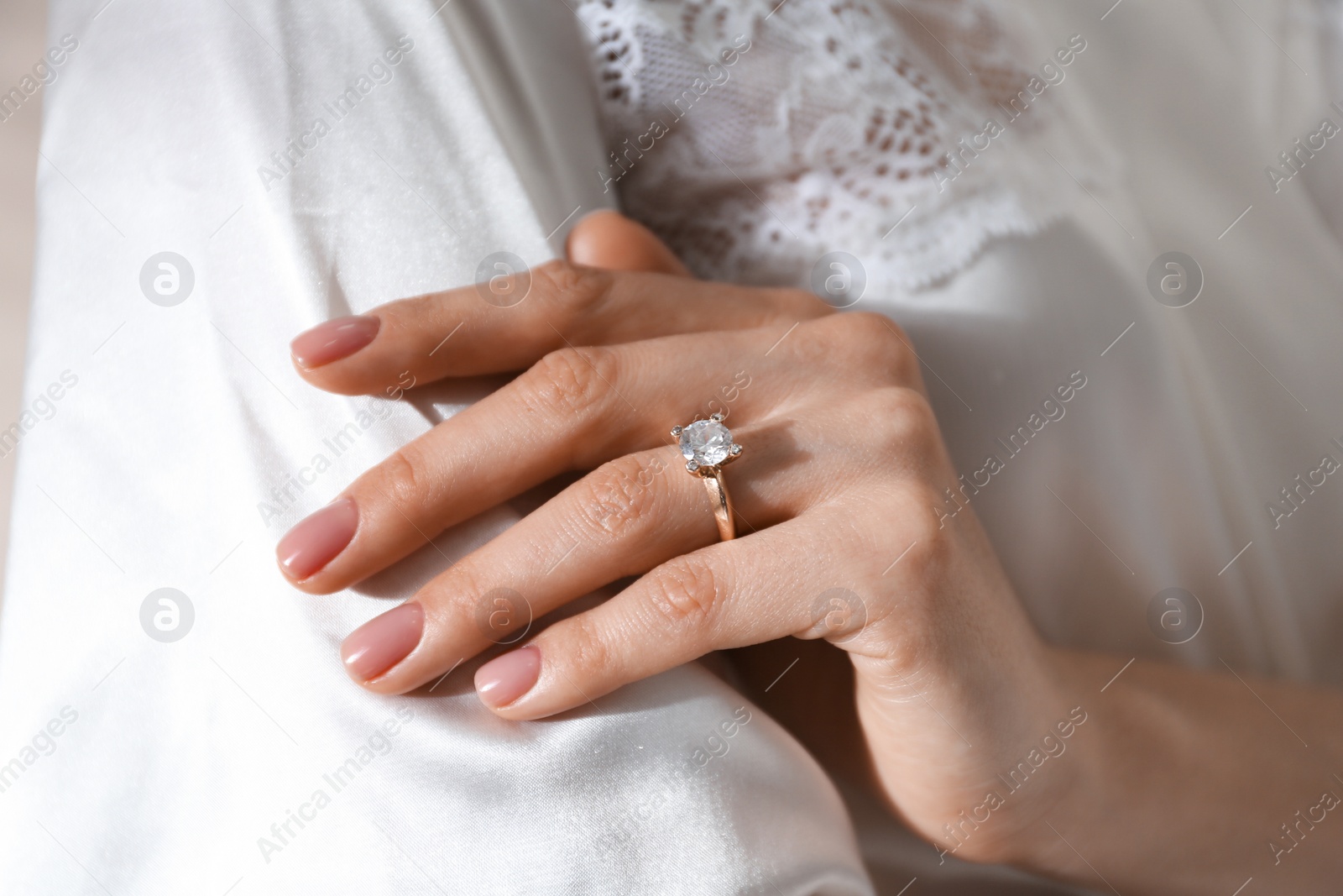 Photo of Young woman wearing beautiful engagement ring, closeup