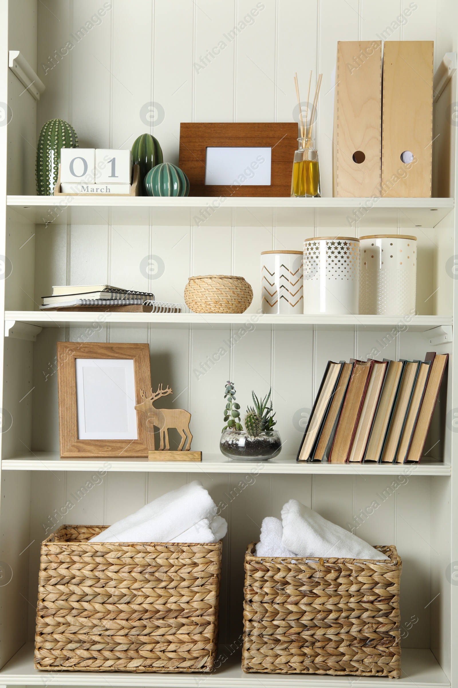 Photo of White shelving unit with books and different decorative elements