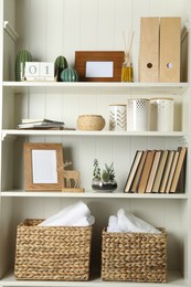 White shelving unit with books and different decorative elements