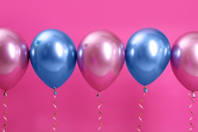 Bright balloons with ribbons on color background