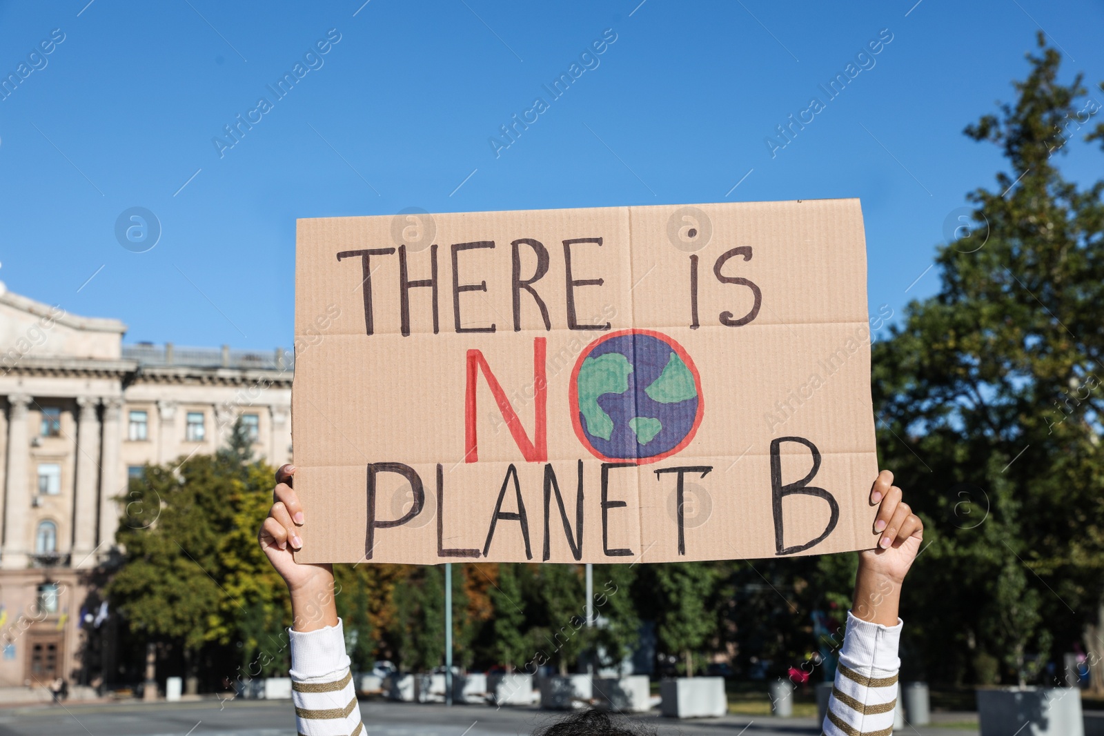 Photo of Young woman with poster protesting against climate change outdoors, closeup