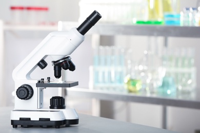 Photo of Modern microscope on table in laboratory. Chemical analysis