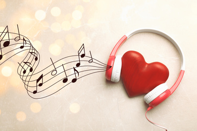 Decorative heart with modern headphones on light background 