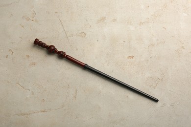 Photo of One magic wand on light textured background, top view