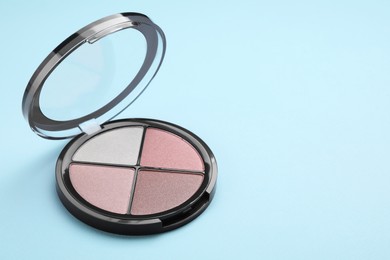 Photo of Colorful contouring palette on light blue background, space for text. Professional cosmetic product