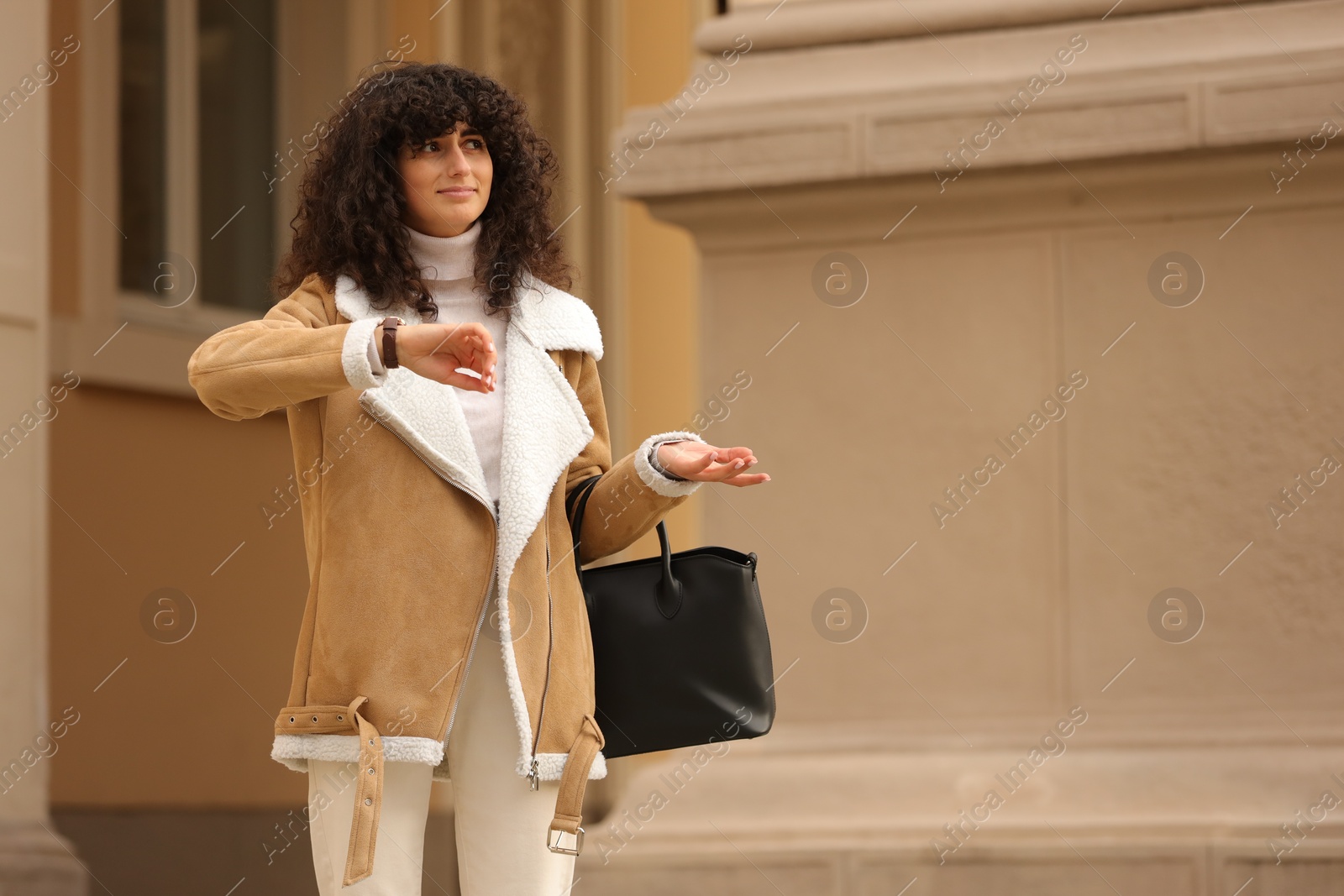 Photo of Being late. Confused woman with bag near building outdoors, space for text