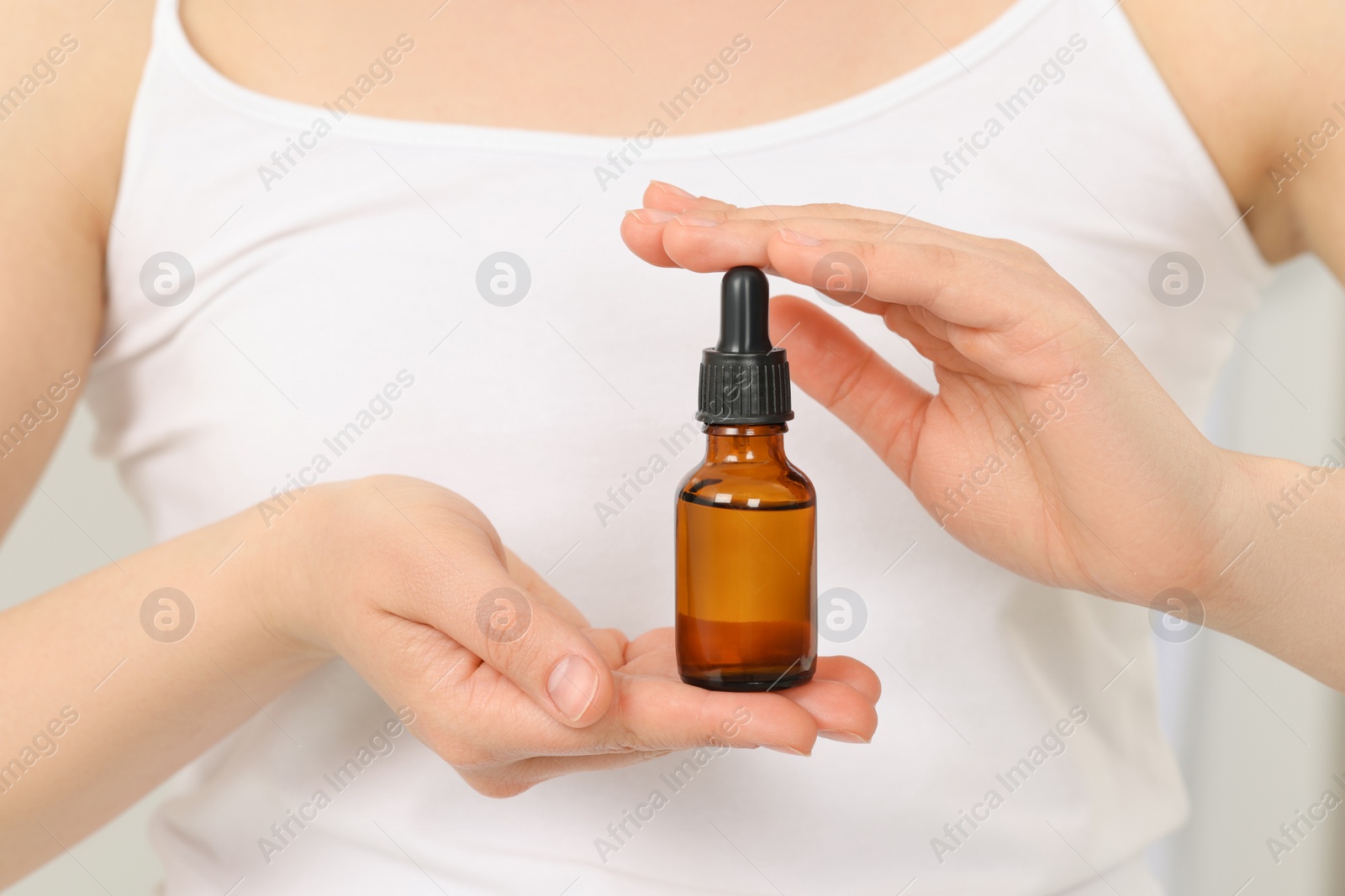 Photo of Woman with bottle of essential oil, closeup