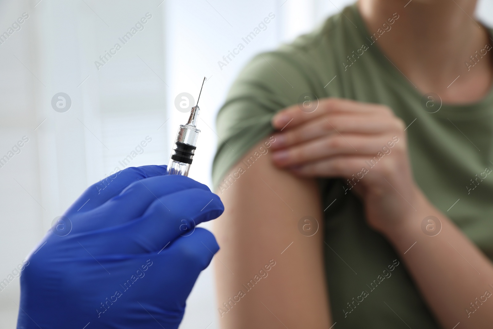 Photo of Doctor giving injection to woman in hospital, closeup. Immunization concept