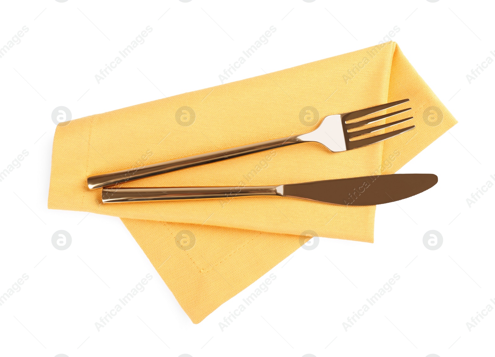Photo of Yellow napkin with golden fork and knife on white background, top view