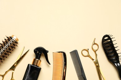 Photo of Different hairdresser tools on beige background, flat lay. Space for text