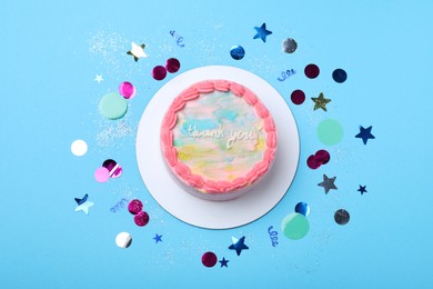 Cute bento cake with tasty cream and confetti on light blue background, flat lay