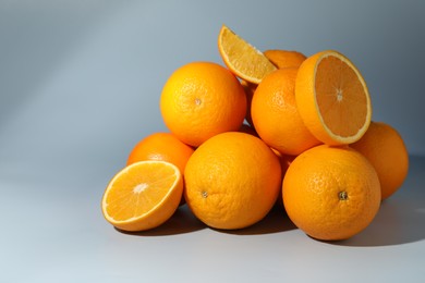 Photo of Many whole and cut oranges on grey background